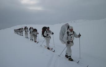 gruppe av menn på ski kledd i hvit