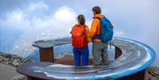 couple standing at the overview map at Mount Gausta